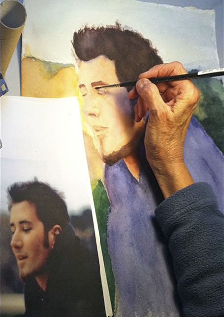 "Holly's hand working on a painting of her son, Toby"